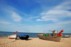 3 barche sedute sulla sabbia sulla spiaggia di Bungalows - Pension Seeper a Sandort