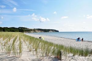 un gruppo di persone che camminano su una spiaggia di Bungalows - Pension Seeper a Sandort
