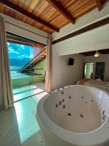 uma banheira num quarto com vista para o oceano em Bela casa c/ vista privilegiada, à 1km da Ilha das Cabras em Ilhabela