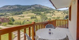 d'une table sur un balcon avec vue sur la montagne. dans l'établissement Chalets des Evettes- appartement vue montagne, à Flumet