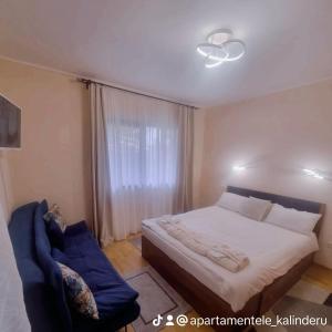 ein Schlafzimmer mit einem Bett und einem blauen Stuhl in der Unterkunft Apartament Kalinderu K3 Busteni in Buşteni