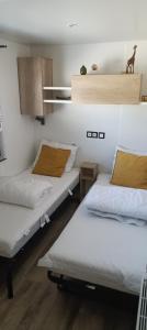 twee bedden in een kamer met witte muren bij Chalet Cozy Cove te Lauwersoog in Lauwersoog