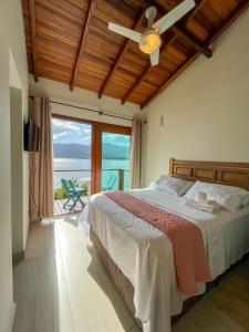 um quarto com uma cama e vista para o oceano em Bela casa c/ vista privilegiada, à 1km da Ilha das Cabras em Ilhabela