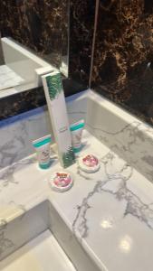 - un comptoir de salle de bains avec deux tasses et un tube de dentifrice dans l'établissement بلند للشقق المخدومة, à Dammam