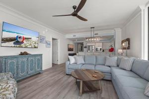 a living room with a blue couch and a table at Perdido Dunes Tower 3E in Orange Beach