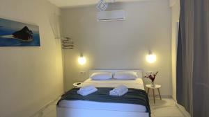 a bedroom with a bed with two towels on it at Zante Art de l'eau in Zakynthos Town