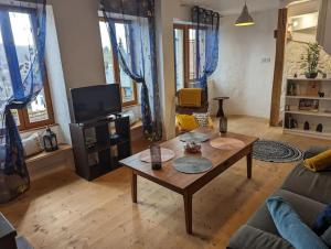 a living room with a coffee table and a tv at Le Petit Perchoir à Aubusson in Aubusson