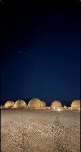un grupo de domos en un desierto por la noche en The Rock Camp en Wadi Rum