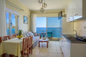 a kitchen and living room with a table and a couch at Perla Apartments in Agios Nikolaos