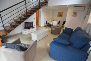 uma sala de estar com mobiliário azul e uma escadaria em RNET Apartments Roses Duplex Granada em Roses