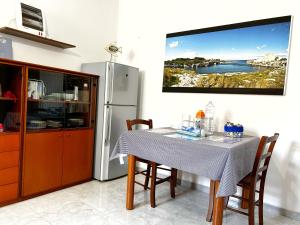 a kitchen with a table and a tv on the wall at L' APPARTAMENTO sul MARE in Agnone Bagni