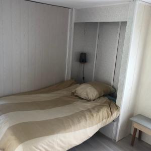 - un petit lit dans une chambre avec une lampe dans l'établissement Camping Atypique Manche SURVILLE, à Surville