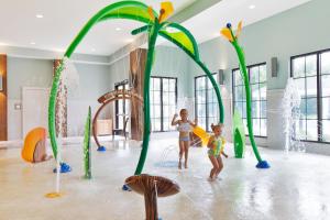two children playing in a play room with water fountains at Direct ocean front condo in Royale Palms, 801 condo in Coffeyville