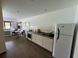 a kitchen with a white refrigerator and a table at El loft mas lindo de Cafayate! in Cafayate