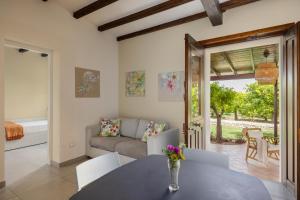 a living room with a table and a couch at Fiore di Vendicari B&B - Sicilian Charme, Lemon Grove and Sea in Noto