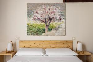 a painting of a tree above a bed at Fiore di Vendicari B&B - Sicilian Charme, Lemon Grove and Sea in Noto