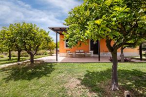 a house with a patio and trees in the yard at Fiore di Vendicari B&B - Sicilian Charme, Lemon Grove and Sea in Noto
