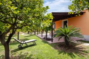 a park bench in the grass next to a building at Fiore di Vendicari B&B - Sicilian Charme, Lemon Grove and Sea in Noto