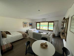 a bedroom with a bed and a table and a bed and a couch at El loft mas lindo de Cafayate! in Cafayate +28 photos