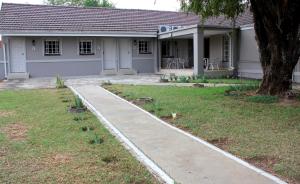 a house with a sidewalk in front of it at The Itumeleng Guest House in Bergville