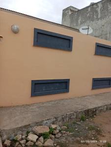 un edificio con tres ventanas laterales en Riche ag, en Cotonou