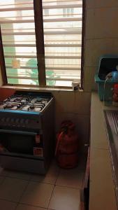 Una estufa en una cocina con ventana. en Riche ag, en Cotonou
