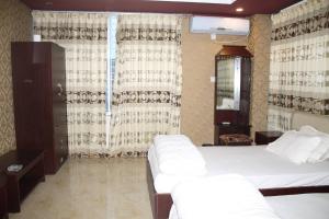 a hotel room with two beds and a window at 78 Firoza Inn in Dhaka