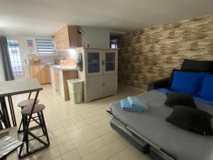 a living room with a bed and a kitchen at Chez mimi & Djo T2 cosy proche Disney et Paris in Dampmart