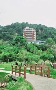 un banco de madera en un parque con un edificio en el fondo en 慕杉居, en Daxi