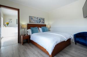 1 dormitorio con 1 cama grande y 1 silla azul en Estalagem Pico D'Agua, en Livramento