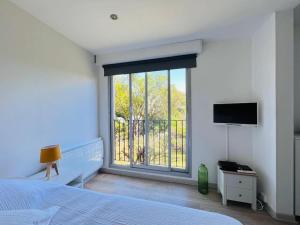 - une chambre avec un lit et un balcon avec une télévision dans l'établissement Studio, piscine, parking, à Saint-Tropez