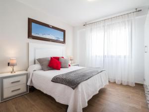 a white bedroom with a bed with red pillows at Casa huerta maria in Chite +33 photos