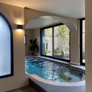 a swimming pool in a house with a window at Hotel de Charme Le Sud Bretagne in Pornichet