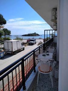 a table and chairs on a balcony with a view of the beach at ISLAND VIEW BEACH APARTMENT in Néa Péramos