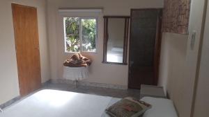 una camera con un letto, una finestra e uno specchio di Rincón Colombiano a Yerba Buena