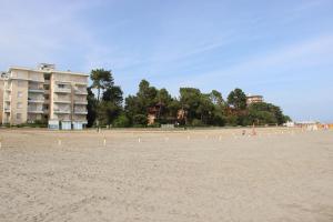 una spiaggia sabbiosa con un edificio sullo sfondo di Felix Grado a Grado-Pineta