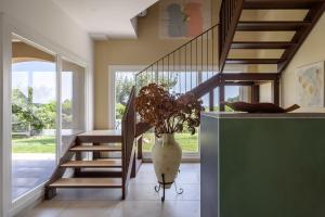 a hallway with a staircase and a vase with a plant at Fiore di Vendicari B&B - Sicilian Charme, Lemon Grove and Sea in Noto