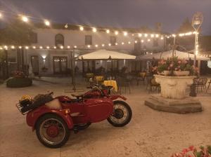 een rode motorfiets geparkeerd voor een patio in de nacht bij Hotel In Sylvis in Sesto al Reghena
