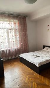 ein Schlafzimmer mit einem Bett vor einem Fenster in der Unterkunft 3х комнатная квартира возле парка in Riwne