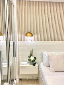 1 dormitorio con 1 cama con una planta sobre una mesa en Alexis Place Azure North, en San Fernando 8 fotos más