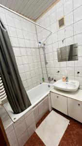 ein Badezimmer mit Badewanne und Waschbecken in der Unterkunft 3х комнатная квартира возле парка in Riwne