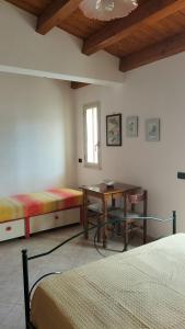 a bedroom with two beds and a desk and a table at Casa Rosellina in Cefalù
