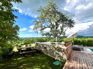 a wooden deck with a picnic table and a tree at Resort Franko Spacious house with a pool in Obrov