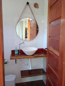 uma casa de banho com um lavatório e um espelho em Chalé do Bosque Corumbau em Prado
