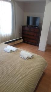 a bedroom with a bed and a dresser with two towels at Mikasa in Niš