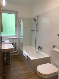a bathroom with a tub and a toilet and a sink at Appartements Domizil in Kaprun +118 photos