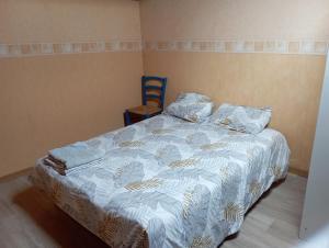 a bed in a bedroom with a blue chair at le T3 du sommet in La Saulce
