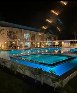 - une grande piscine éclairée la nuit dans l'établissement Flat Villas Manatee Rota Ecológica dos Milagres, à Porto de Pedras