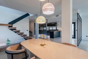 eine Küche und ein Esszimmer mit einem Tisch und einer Treppe in der Unterkunft Villa con Piscina Privada in Gelves