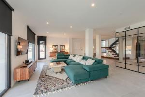 ein Wohnzimmer mit einer grünen Couch und einem Tisch in der Unterkunft Villa con Piscina Privada in Gelves